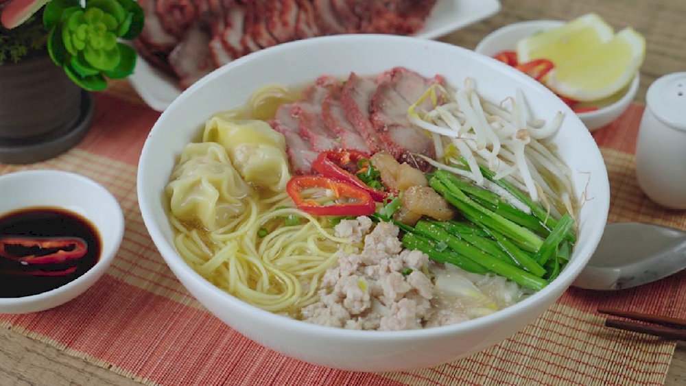 The dish is served with lime, chili, and fresh herbs to enhance the flavor